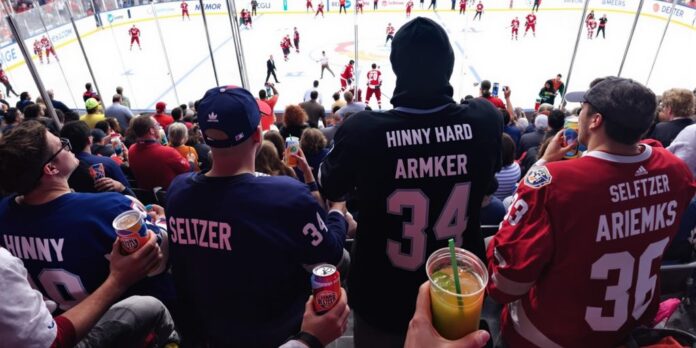 Fans enjoying Hinny Hard Seltzer at a hockey game.